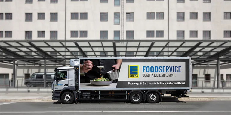 EDEKA Foodservice LKW vor einem Gebäude.